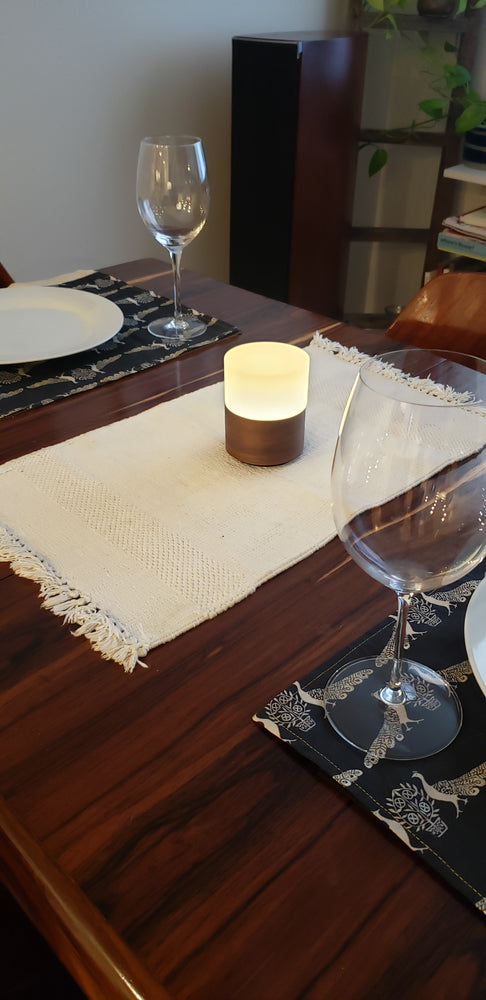 Ola portable lamp with real Walnut veneer base placed at centre of dinner table.